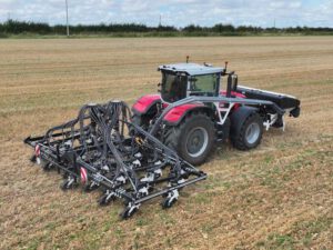 Die Agrisem T-BOSS Direktsaatmaschine im Einsatz auf einem Stoppelfeld mit Traktor, angebundenem Schlauchsystem und Säeinheiten.